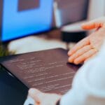 Programista analizuje kod na tablecie w nowoczesnym biurze