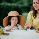 Mama z córką na spokojnym letnim pikniku z owocami na łonie natury